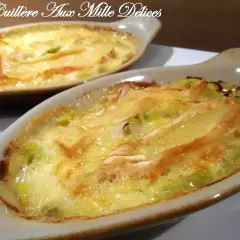 Gratin de poireaux au reblochon, fondant et doré, servi dans des ramequins individuels. Un délice réconfortant.